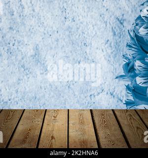 Background flowers on a textured stucco wall and blank wooden planks in the foreground. Stock Photo