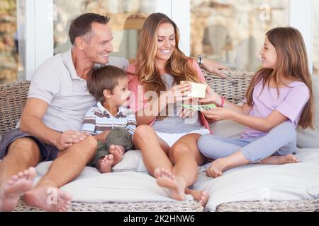 Spoiling mom on this special day. Happy young family of four celebrating mothers day. Stock Photo