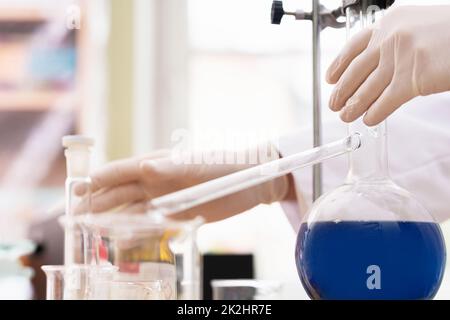 Retort flask filled with a blue substance in a laboratory Stock Photo