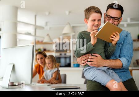 Device technology family online education concept. Happy family with digital devices at home. Stock Photo