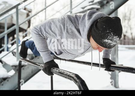 Athletic man doing push ups during his calisthenics winter workout Stock Photo