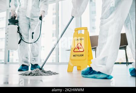 Decontamination makes a big difference. Shot of healthcare workers wearing hazmat suits and sanitising a room during an outbreak. Stock Photo