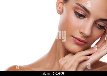 Soft to the touch. Studio shot of a beautiful young woman touching her face isolated on white. Stock Photo