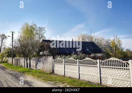 Old barn with fence in countryside. Road in the village, summer rural landscape Stock Photo