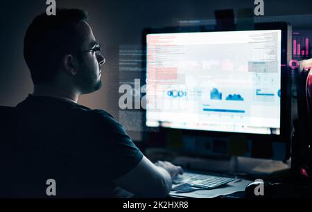 Developing in progress. Cropped shot of a young computer programmer looking through data. Stock Photo