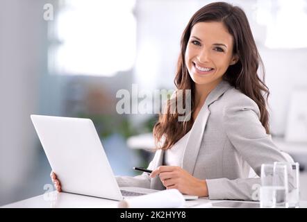 She's made it. Shot of an attractive businesswoman sitting at her desk in an office. Stock Photo