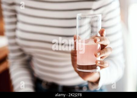 Get a good dose of health in a glass. Cropped shot of a woman having an effervescent drink at home. Stock Photo