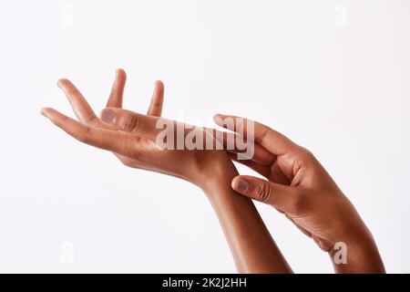 I keep them soft by moisturising. Studio shot of an unrecognizable womans hands against a white background. Stock Photo