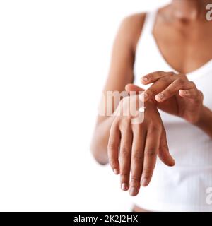 Moisturize atleast once a day. Studio shot of an unrecognizable woman moisturising her hands. Stock Photo