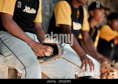 Were ready to play. Cropped shot of a group of young baseball players sitting together on the bench during a game. Stock Photo