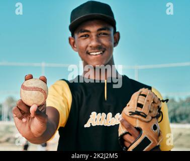 Baseball is my number one choice. Shot of a young baseball player wearing a baseball mitt and holding a ball. Stock Photo