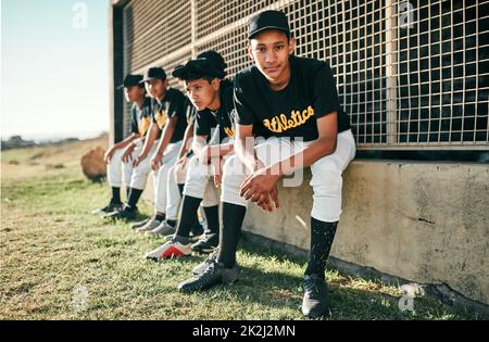 I wouldnt want to be anywhere else. Shot of a group of baseball players sitting together on a field. Stock Photo