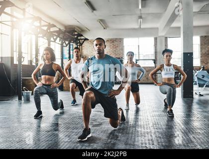 Every step taken towards fitness pays off. Shot of a group of young people  doing lunges together during their workout in a gym. Stock Photo by  ©PeopleImages.com 567815914