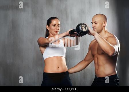 With help of gym equipment. Two women in sportive wear and with slim bodies  have fitness yoga day indoors together Stock Photo - Alamy