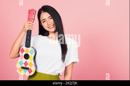 woman teen confident smiling face hold acoustic Ukulele guitar Stock Photo