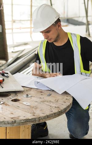Worker is checking blueprints during his work on a construction Stock Photo