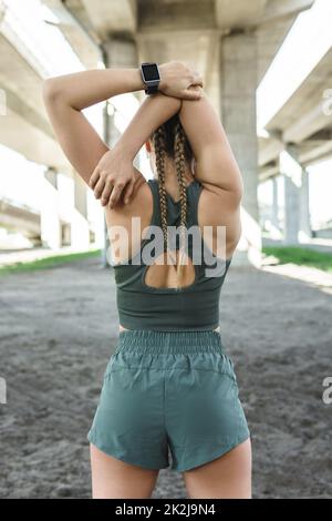 Sportive woman is stretching during fitness workout on a street Stock Photo