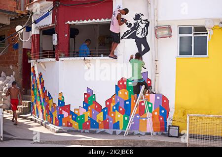 Urban artists. Shot of two young graffiti artists painting a design on a wall. Stock Photo