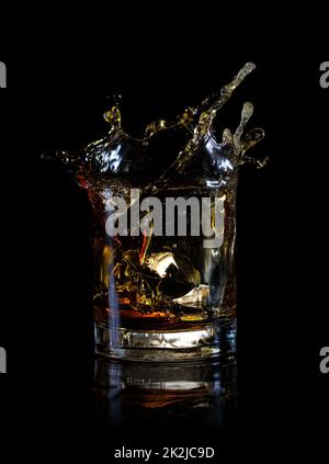 Splash from ice cube in glass of whiskey Stock Photo