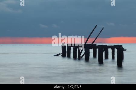 Long Exposure Of The Old Wooden Pier At Snettisham At Sunset With Rain Cloud Approaching, Snettisham UK Stock Photo