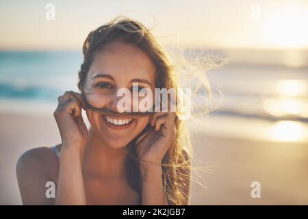 The secret of happiness is freedom. Cropped shot of a woman playfully making a mustache with her hair. Stock Photo