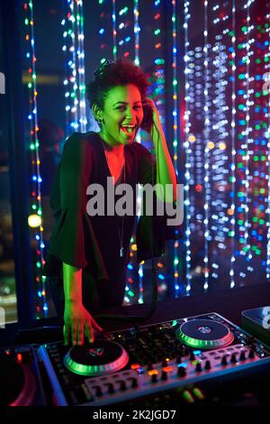 Shes the headline act. Portrait of an attractive young female dj playing in a nightclub. Stock Photo