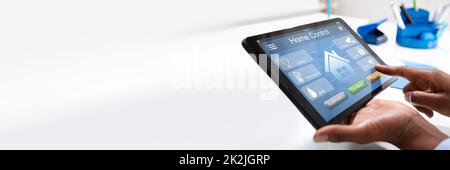 Person Using Home Control System On Tablet Stock Photo