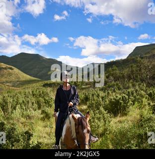 Horse riding in the outback. Shot of an attractive young woman riding a horse. Stock Photo