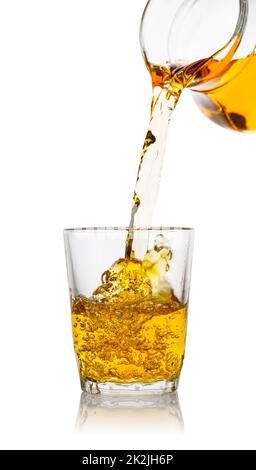 Apple juice pours from the decanter into transparent glass Stock Photo