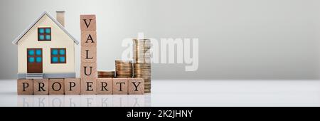 Property Value Text With House Model And Stacked Coins Stock Photo