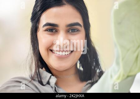 Shiny windows for the win. Shot of a young woman washing windows at home. Stock Photo