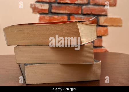 Three books lying on top of each other on the table Stock Photo