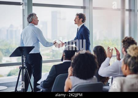 The floor is yours. Cropped shot of two businessmen shaking hands during a seminar in the conference room. Stock Photo