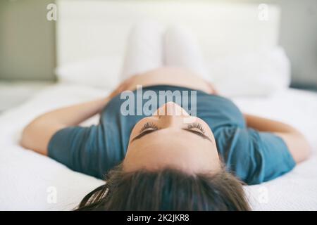 Taking it easy on my last trimester. Shot of a young pregnant woman relaxing at home. Stock Photo