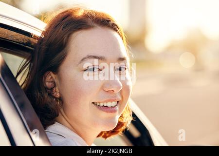 See you on the other side of adventure. Portrait of a young woman traveling in a car. Stock Photo