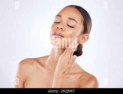 Feeling fulfilled within myself. Shot of a young woman posing against a studio background. Stock Photo