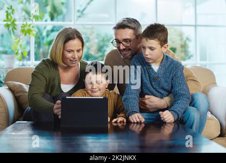 What do you feel like watching. Shot of a family using a digital tablet together. Stock Photo