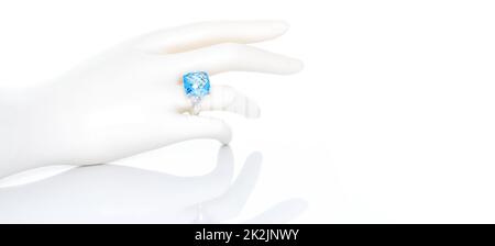 Cushion cut blue topaz ring on plastic mannequin female hand. Collection of natural gemstones accessories. Studio shot Stock Photo