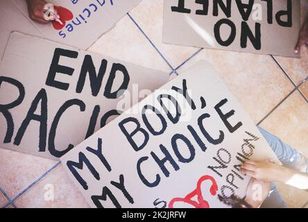Writing on protest cardboard sign or banner for racism justice, abortion and global climate change problem. Hands of crowd in support of Stock Photo