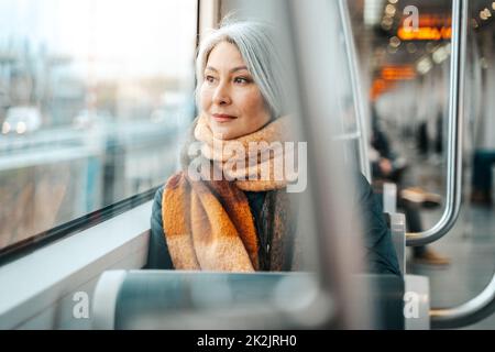 Senior woman sitting on a train are oving to the destination Stock Photo