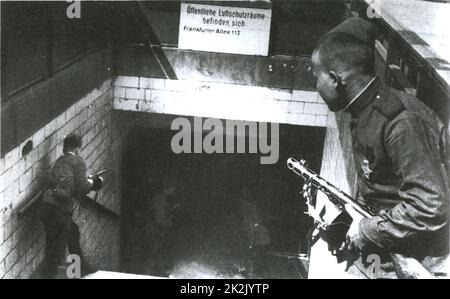 Soviet Russian soldiers enter the Frankfurter Allee railway station in Berlin 1945, carrying submachine guns. The sign reads: “Public air raid shelters are situated in Frankfurter Allee 113.”   World War II