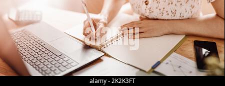 Woman writing in notebook at the office Stock Photo