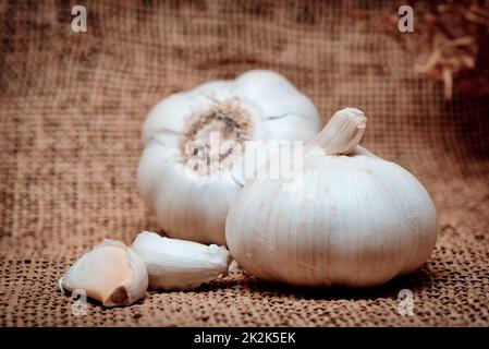 Garlic on the linen texture. Close-up. Color tone tuned photo. Stock Photo