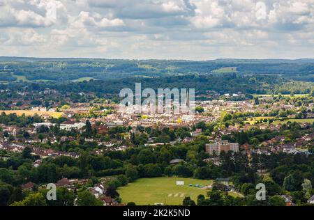 Elevated distant panoramic view from Box Hill of the town of Dorking in Surrey and surrounding wooded North Downs countryside in mid-summer Stock Photo