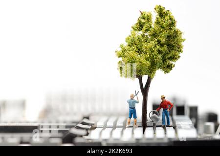 IT growing concept. Miniature gardeners on motherboard Stock Photo