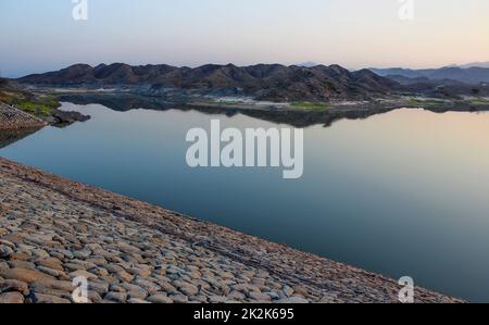 Scenic Hatta dam lake with characteristic mountain range landscape in the background in Dubai emirate of United Arab Emirates Stock Photo