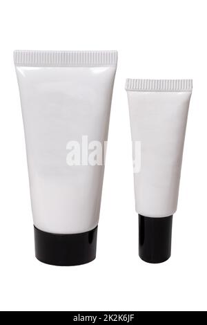 Containers for beauty products. Close-up of two white cosmetic tubes of different sizes with black caps. Skin care product or other products with space for your label isolated on a white background. Macro. Stock Photo
