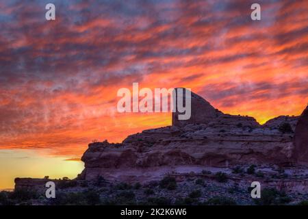 Colorful sunset clouds over the half-dome rock formation at the Green River Overlook in Canyonlands National Park, Utah. Stock Photo