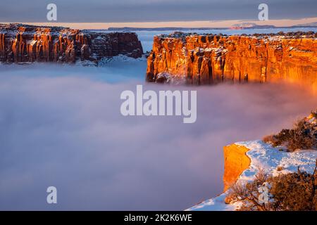 First light at sunrise on the Wingate cliffs of Junction Butte & Grandview Point with a sea of clouds below. Canyonlands NP, Utah.  A winter temperatu Stock Photo