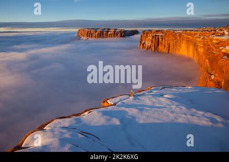 First light at sunrise on the Wingate cliffs of Junction Butte & Grandview Point with a sea of clouds below. Canyonlands NP, Utah.  A winter temperatu Stock Photo